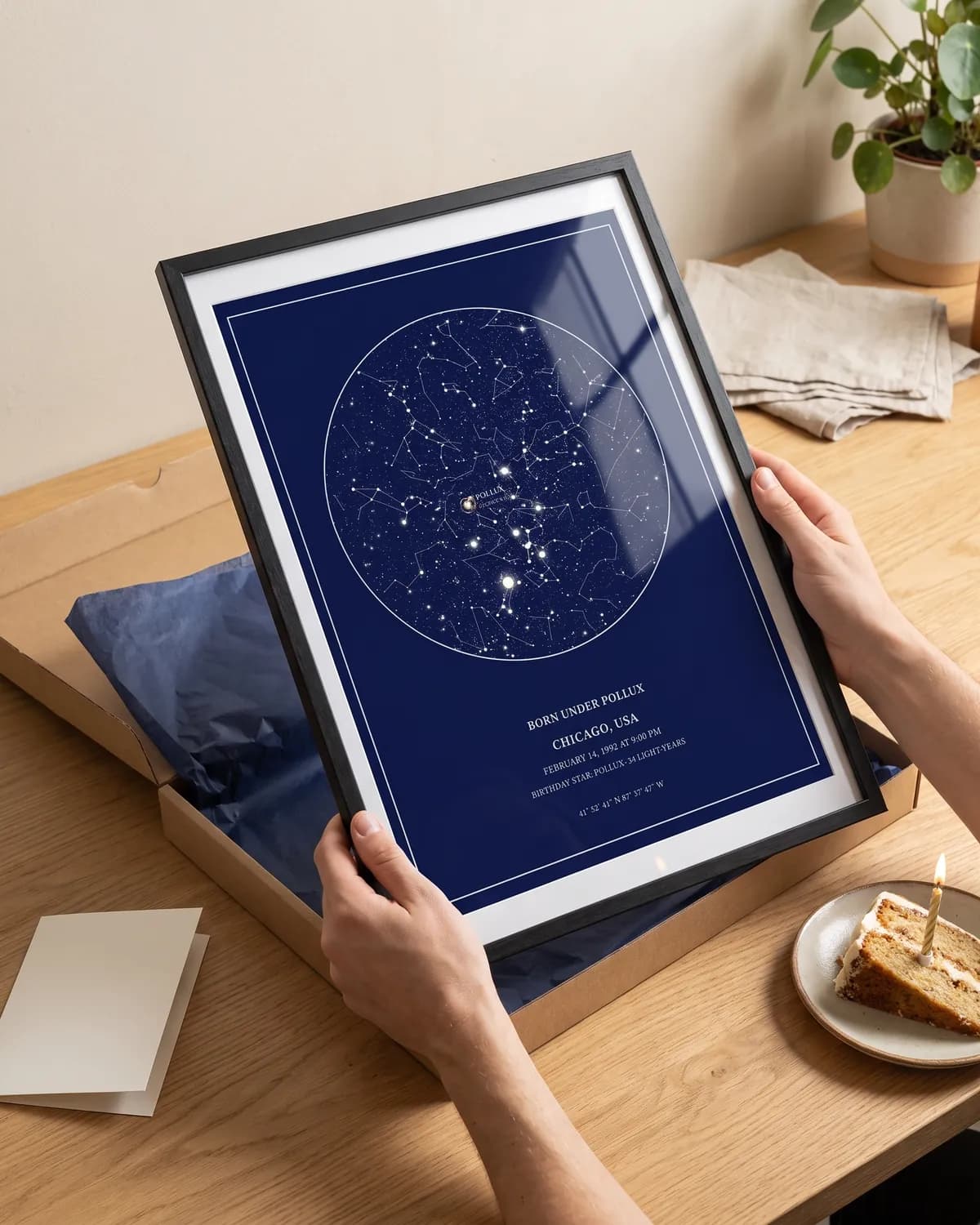 A framed navy star map being unwrapped next to a slice of birthday cake