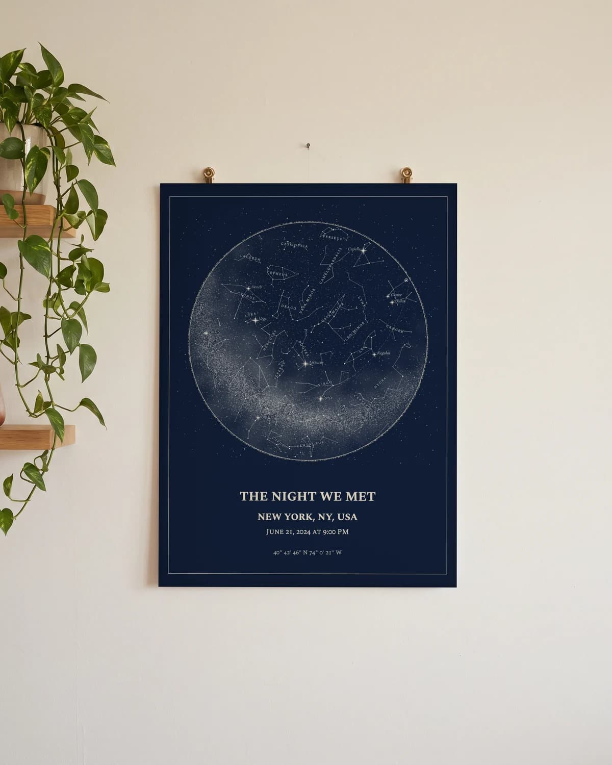 Navy star map poster of a New York night sky, hung unframed on a wall with brass clips