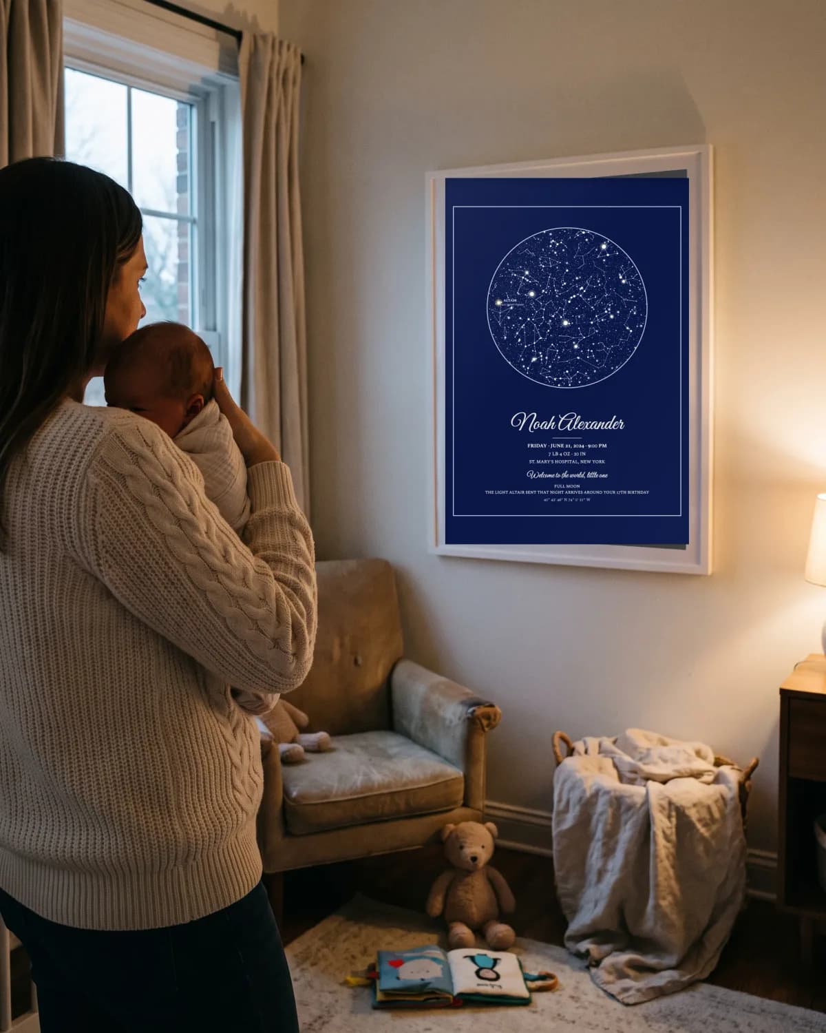 A mother holding her newborn beside their birth poster at dusk