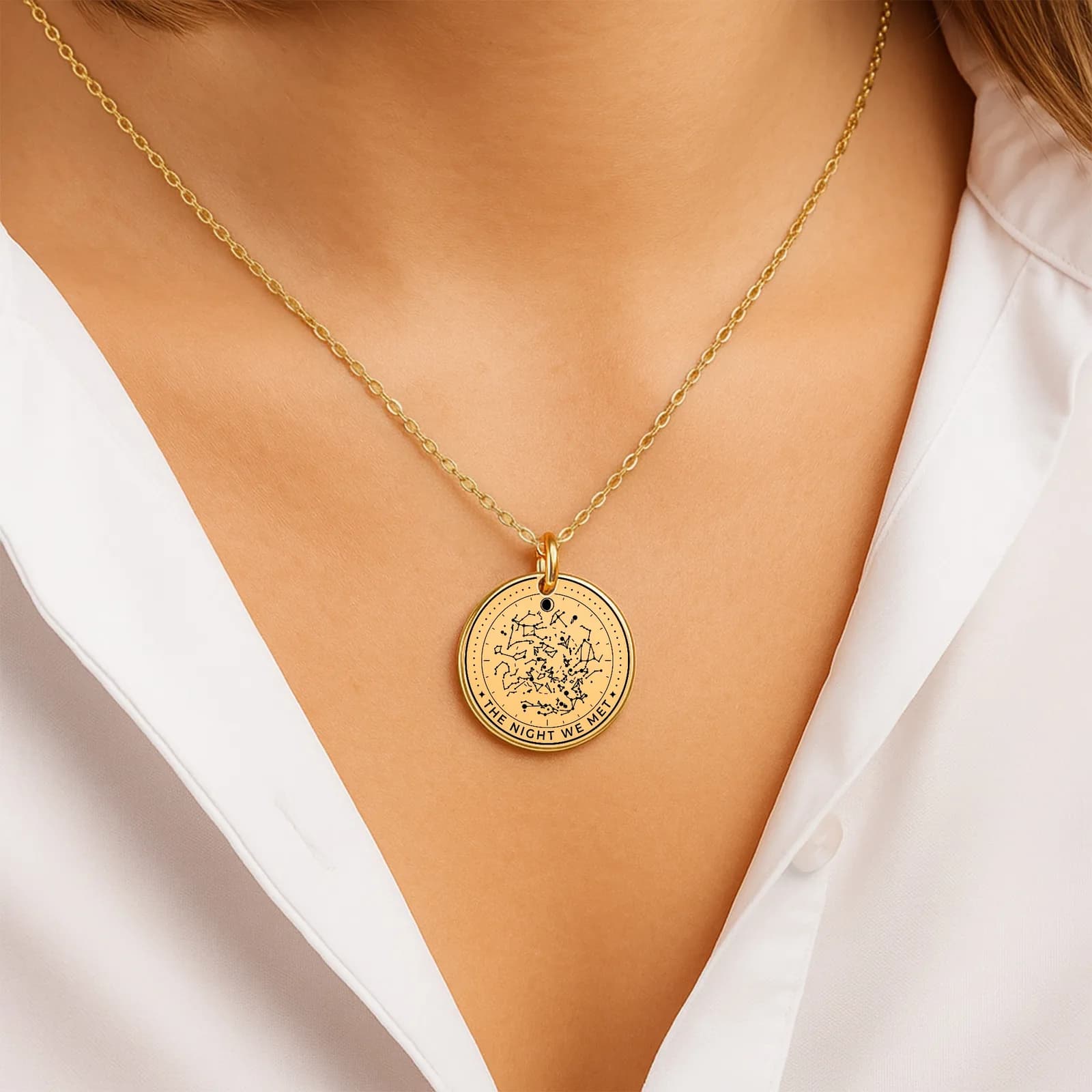 A gold star map coin necklace worn on the collarbone with a white shirt