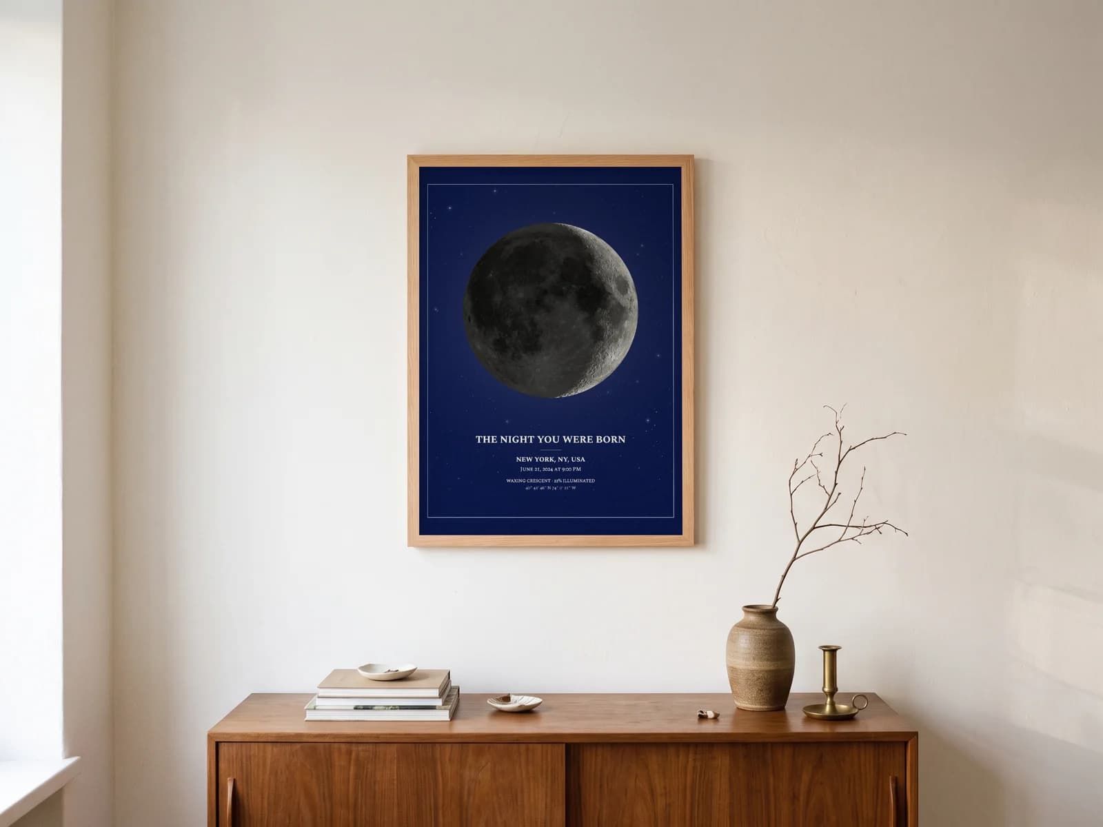 Moon Phase Poster in Midnight Navy, natural wood frame above a sideboard